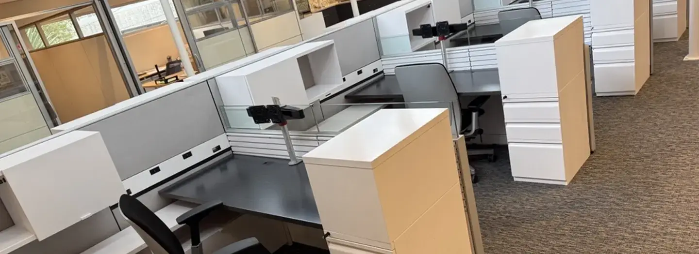 Office Furniture Connection offers smart and efficient Knoll Currents workstations with modern white storage (open and closed), grey panels with white trim, and black worskurfaces with monitor arms. Filing pedestals with a locker compartment on top. Photo of used furniture taken at a high angle.