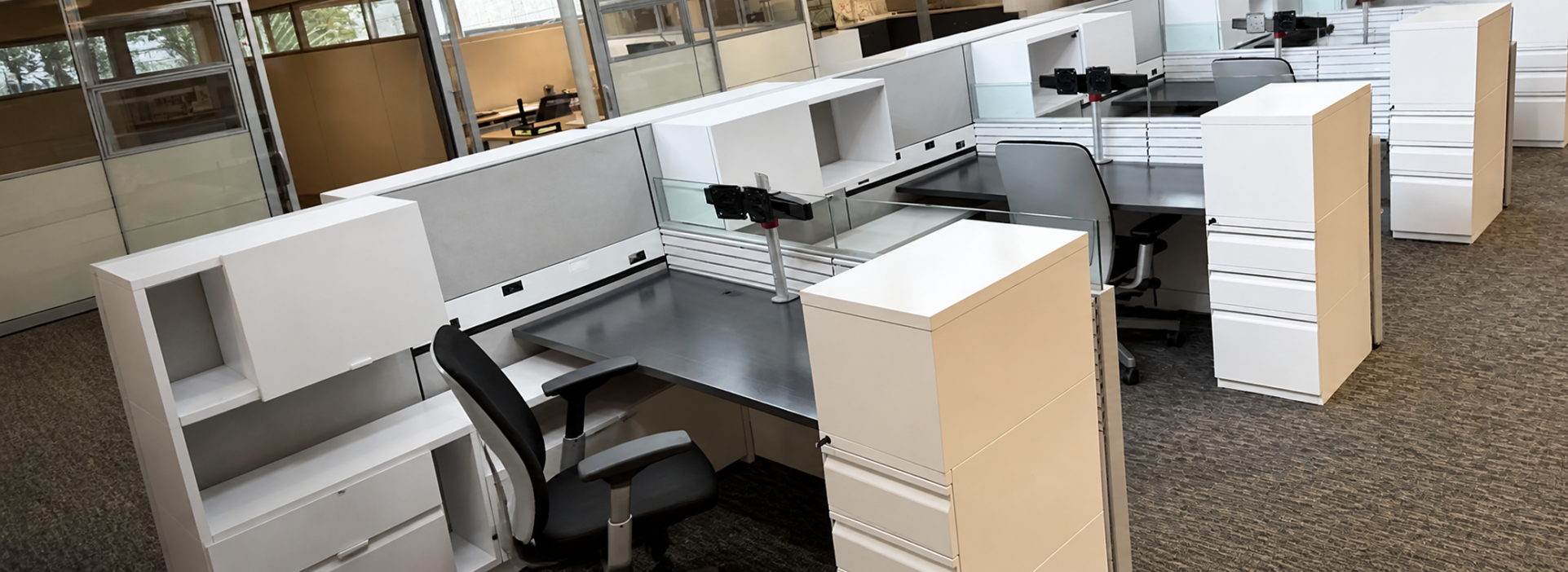 Office Furniture Connection offers smart and efficient Knoll Currents workstations with modern white storage (open and closed), grey panels with white trim, and black worskurfaces with monitor arms. Filing pedestals with a locker compartment on top. Photo of used furniture taken at a high angle.
