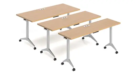 AIS Day-to-Day Flipnest set of three light oak laminate rectangular training tables with flip-top mechanism, integrated power outlets on the surface, silver metal folding legs, and black casters, arranged in a nested configuration against a plain white backdrop. Versatile and tech-ready options ideal for dynamic training environments.