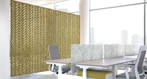 Large rectangular hanging acoustic panels in a mustard yellow with a herringbone cutout pattern suspended above modern benching workstations with white tops in a bright open office. Additionally ideal as room dividers for controlling noise and improving focus in busy collaborative environments.