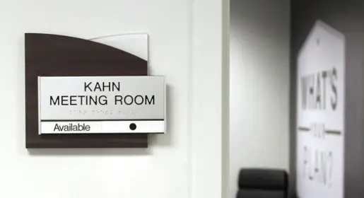 Modern frosted acrylic workstation signage with sleek black metal wording mounted on black and frosted acrylic half arch shapes. Perfect for clear office or desk naming, wayfinding, and personalized branding in agile team environments.