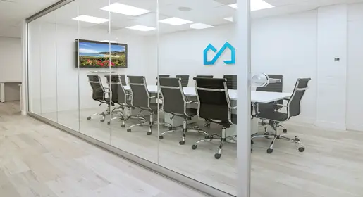 NxtWall View frameless glass architectural walls create a sleek conference room with table and 12 Eames chairs with seamless door integration for light-filled workspaces
