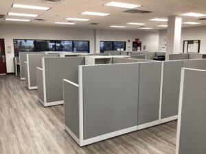 Remanufactured Knoll Morrison workstations with 56H bold grey panels, maple laminate surfaces, and ergonomic task chairs set up in a large open office space. Cost-effective solution for outfitting entire office floors quickly.