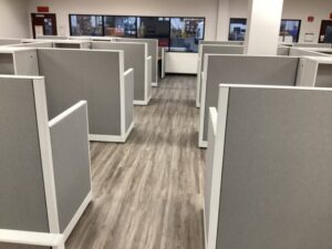 Remanufactured Knoll Morrison workstations with 56H bold grey panels, maple laminate surfaces, and ergonomic task chairs set up in a large open office space. Cost-effective solution for outfitting entire office floors quickly.
