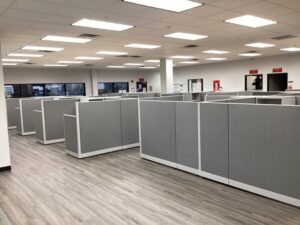 Remanufactured Knoll Morrison workstations with 56H bold grey panels, maple laminate surfaces, and ergonomic task chairs set up in a large open office space. Cost-effective solution for outfitting entire office floors quickly.