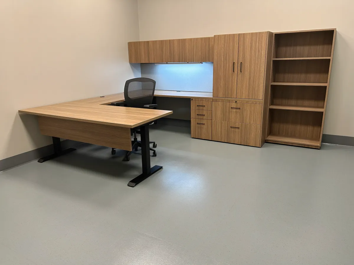 Contemporary modular private office setup from OFC CONNECT series featuring oak wood laminate U-shaped adjustable height desk with modesty panel, integrated power outlets, overhead storage cabinets, lateral filing, and box box file pedestal for focused work – affordable executive workspace solutions by Office Furniture Connection Houston TX.