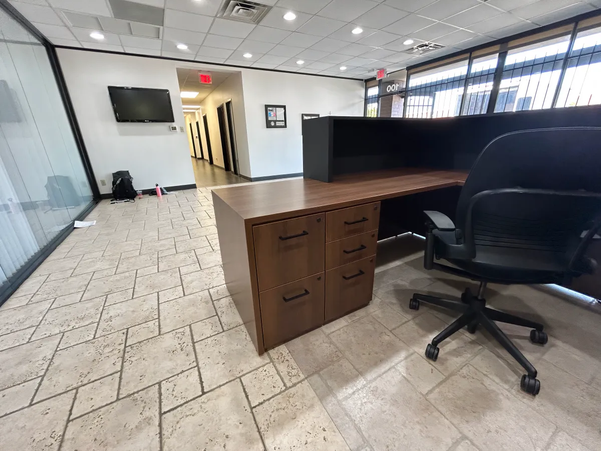 Modern two-tone reception station in OFC CONNECT Series featuring rich walnut laminate worksurface, black privacy panel, built-in pedestal storage, and clean lines – versatile reception desk furniture for Houston businesses from Office Furniture Connection TX.