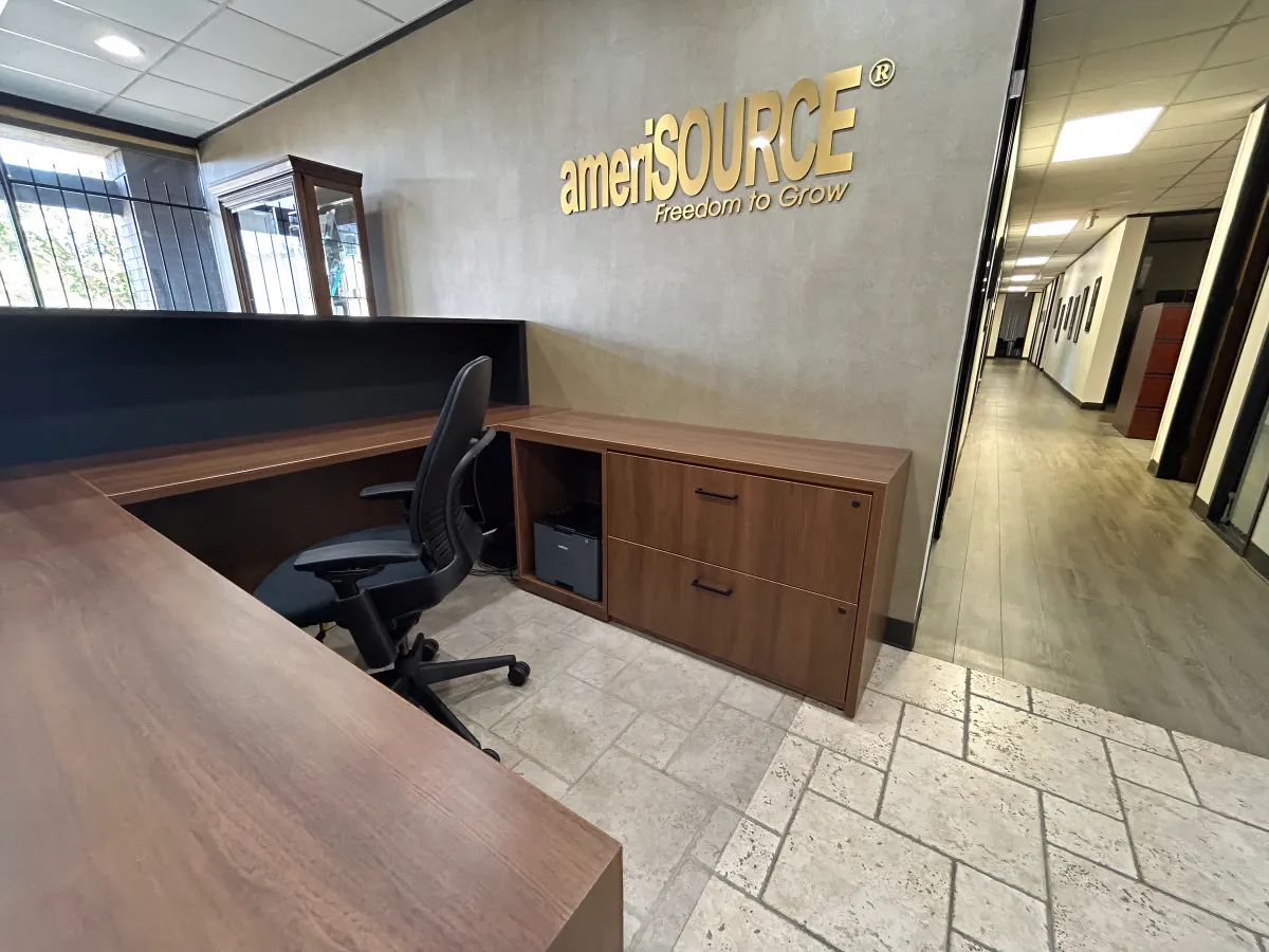 Modern two-tone reception station in OFC CONNECT Series featuring rich walnut laminate worksurface, black privacy panel, built-in pedestal storage, and clean lines – versatile reception desk furniture for Houston businesses from Office Furniture Connection TX.
