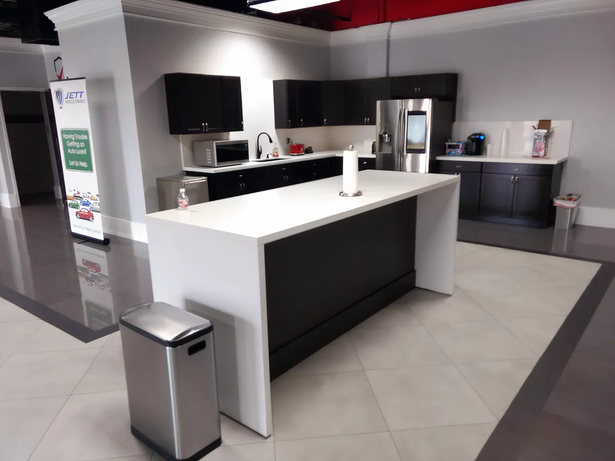 Modern employee breakroom from OFC CONNECT Series with dark espresso wood laminate cabinets, white laminate waterfall island, stainless appliances, and unique tile flooring – complete corporate cafe and kitchen solutions by Office Furniture Connection Houston TX.