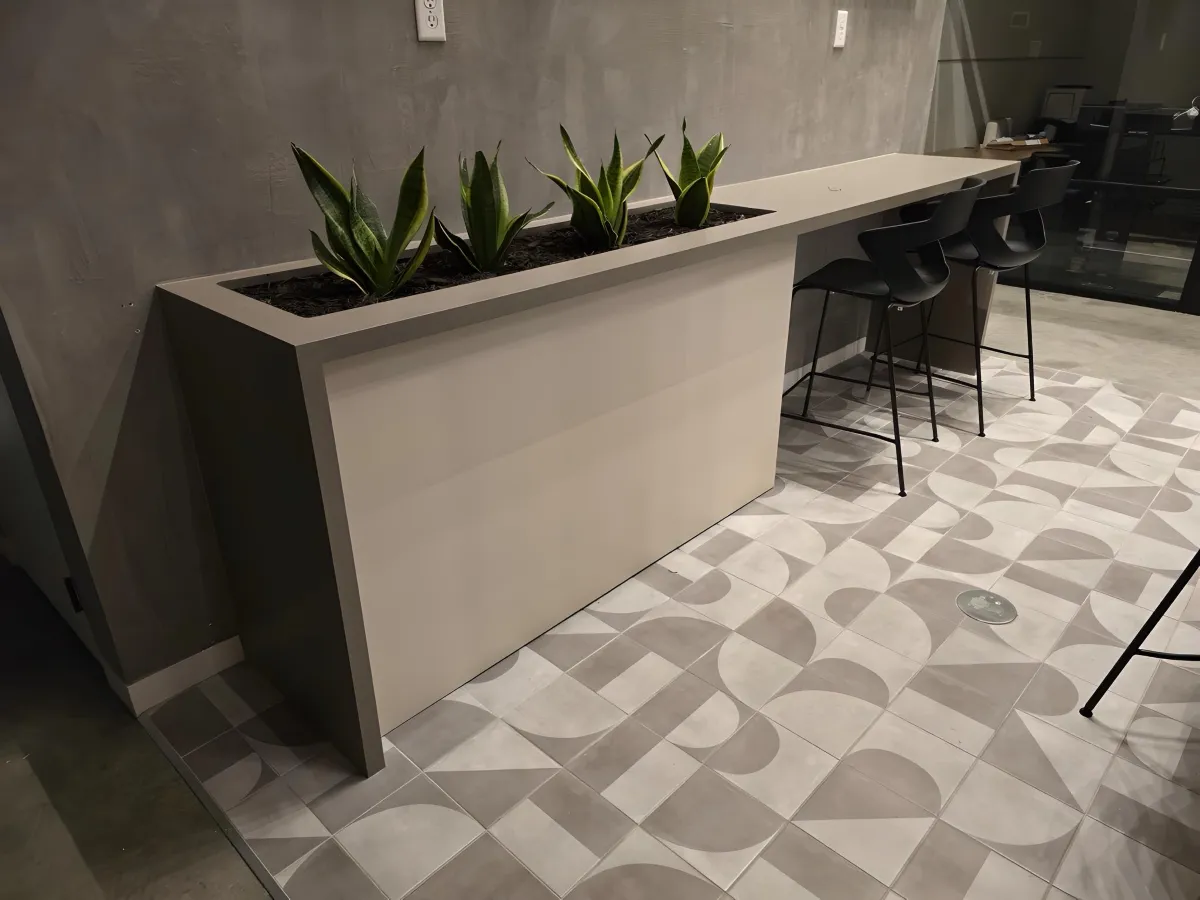 High cafe bar table from OFC CONNECT Series with built-in planter box filled with succulents, neutral laminate top, and black cafe stools – space-saving modern breakroom and collaboration solutions by Office Furniture Connection Houston TX.