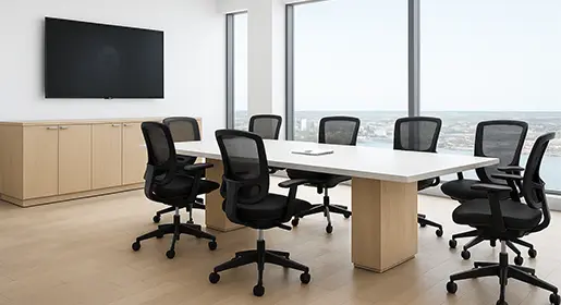Modern executive conference room with a rectangular 10-seat white laminate top and light wood laminate bases conference table, seven black mesh ergonomic chairs, matching credenza with wall-mounted TV, and large floor-to-ceiling windows overlooking a bay area. Ideal for professional board meetings and client presentations.