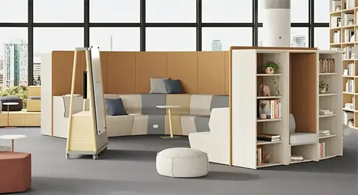 Modern university commons with tiered wood bleacher seating, modular privacy pods, curved upholstered sofa walls, mobile whiteboard, ottomans, and open bookcases for collaborative student lounging and group study.