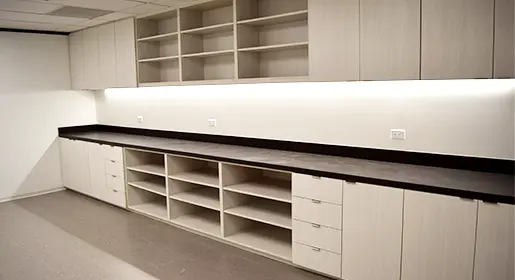 Custom CONNECT storage wall by Office Furniture Connection with 18-foot dark laminate counter, light colored laminate open shelving, closed cabinets and drawers for organized office storage