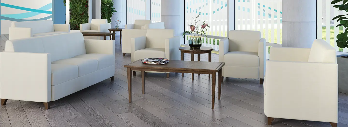 Crisp white cube sized lounge chairs and sofas interspersed in a bright, airy, space for guests and employees