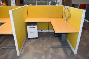 Remanufactured Knoll Morrison cubicle with vibrant yellow 48H panels, height-adjustable desk, dual monitor arm, and upholstered box/file mobile pedestal in a modern office showroom. Perfect for energetic, private workspaces.