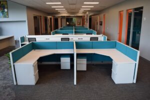 Remanufactured Knoll Morrison teal 48H panel cubicles with white computer corner desks, integrated power, file/file pedestals, and upholstered mobile pedestals in a stylish office with colorful doors and artwork. Excellent for contemporary office redesigns.