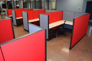 Remanufactured Knoll Morrison workstations with 56H bold red/ and blue panels, white laminate surfaces, and ergonomic task chairs set up in a large open office space. Cost-effective solution for outfitting entire office floors quickly.