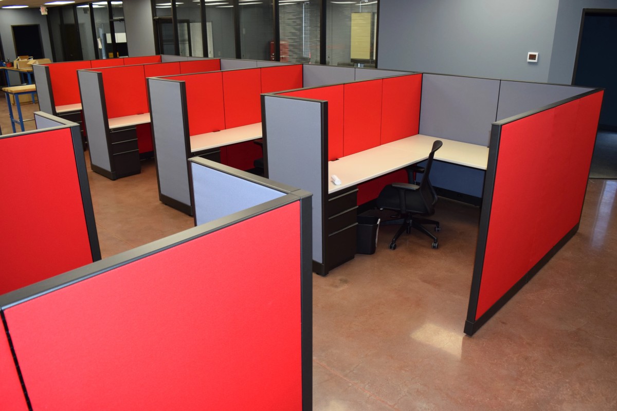 Remanufactured Knoll Morrison workstations with 56H bold red/ and blue panels, white laminate surfaces, and ergonomic task chairs set up in a large open office space. Cost-effective solution for outfitting entire office floors quickly.