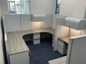 Remanufactured Knoll Morrison cubicle with 64"h gray panels, white laminate worksurfaces, file/file pedestal, overhead closed storage, and black mesh task chair.