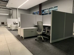 Large open office with row of remanufactured Knoll Morrison cubicles featuring 64"h gray fabric panels, white worksurface and free standing lateral file with greay orgonomic task chair.