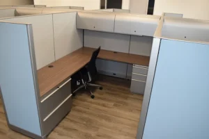 Pod of remanufactured Knoll Morrison cubicles with 64"h gray and blue panels, wood HP laminate worksurfaces with grommets, overhead lockable storage, 2-drawer lateral file and box/box/file pedestal for maximum privacy, workspace, and storage.