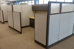 Row of Knoll Morrison remanufactured cubicles with light gray 64" panels featuring 16" frosted glass and 48" panel returns, overhead storage in dark gray with tasklights, light-tone wood laminate worksurfaces and dark gray lateral files for just the right amount of privacy and light.