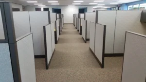 Aisle in corporate office with remanufactured Knoll Morrison cubicles on either side with light gray 64" panelsand 48" panel returns to open up the space and provide as much outdoor light as possible.