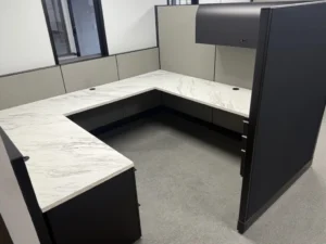 Knoll Morrison remanufactured cubicles with light and dark gray 64" panels and 48" low panels to maximize sunlight from windows. Workstation features U-shaped stone inspired laminate with grommets, overhead locking storage and tasklight, and box/box/file pedestal for a creative, light filled workspace.