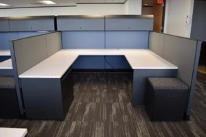 Remanufactured Knoll Morrison cubicle with 64"h blue and 48"h gray panels, white laminate U-shaped worksurface, two overhead lockable storage units, one lateral file and one upholstered mobile ped. An office that provides focused work as well as easy collaboration