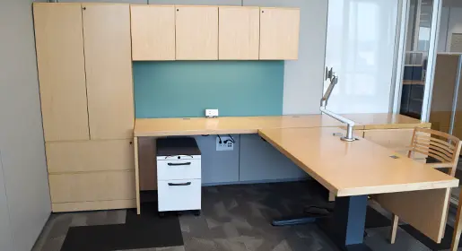Remanufactured Knoll Morrison L-shaped private office furniture pieces include a sit stand desk with a monitor arm, and box/file pedestal, and closed storage that includes lateral files and overhead shelving.
