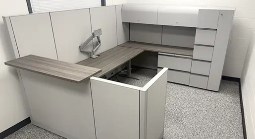 A spacious Knoll remanufactured reception desk with grey wood laminate worksurfaces, light grey fabric panels, overhead storage, a wardrobe tower, and a two drawer lateral file. A bonus includes the monitor arm.