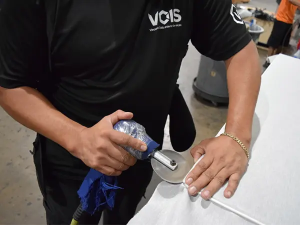 OFC installer reupholstering a Knoll panel for a remanufactured office furniture cubicle with new fabric, a part of our sustainable remanufacturing process