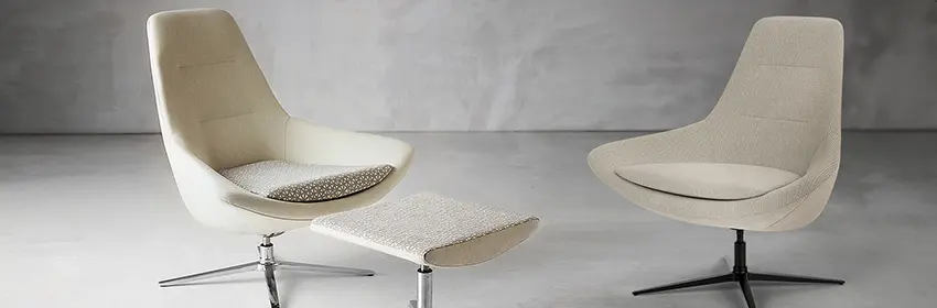 Pre-owned furniture is available and here we show two cream fabric, modern 70's inspired lounge chairs wtih small matching ottoman that are the types of used furniture we get from our sustainable liquidations