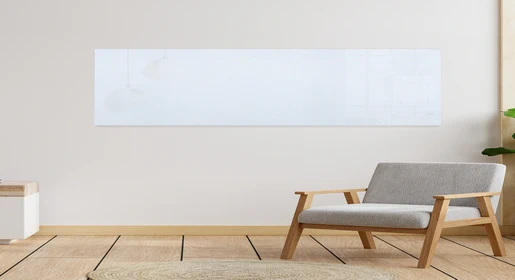 Ultra-wide seamless frameless glass dry-erase marker board spanning entire wall above modern wood lounge chair, reflecting pendant lights – premium large-format writable wall for creative brainstorming and executive offices from Office Furniture Connection Houston TX.