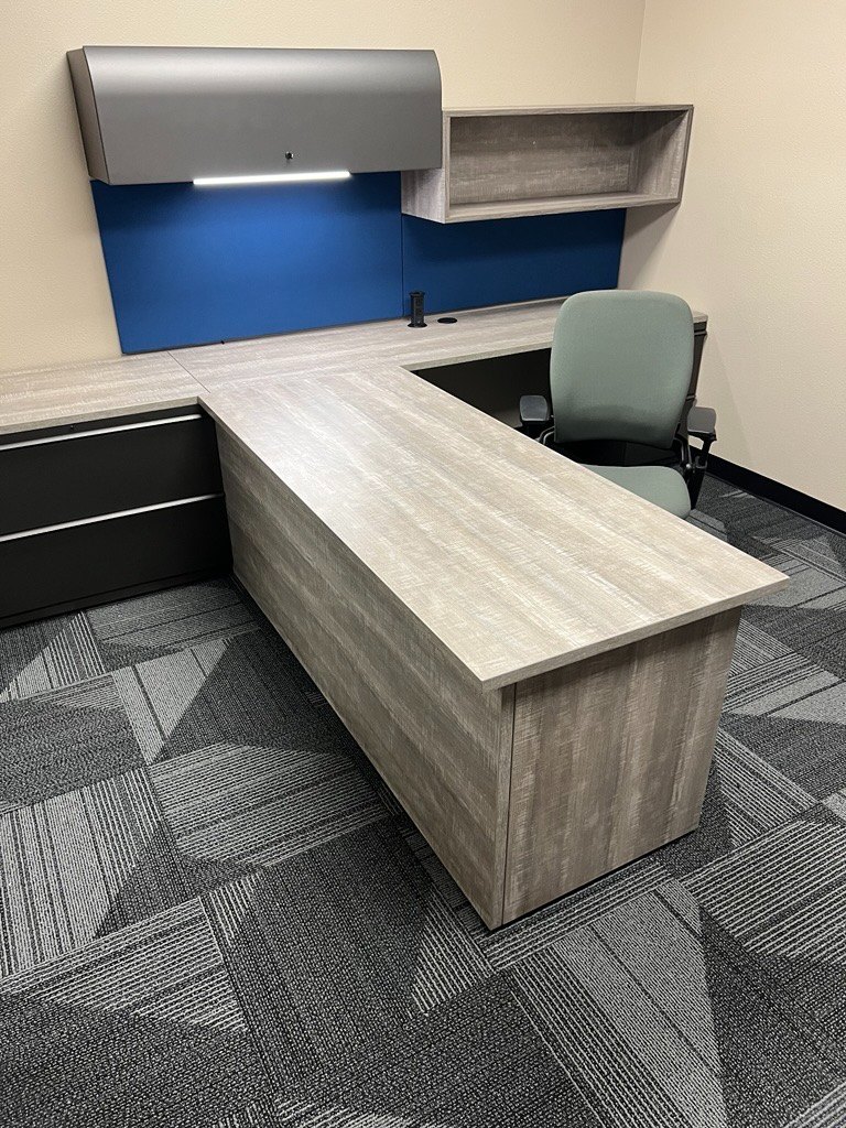 Gray laminate worksurfaces and bookshelf with steel overhead and lateral files