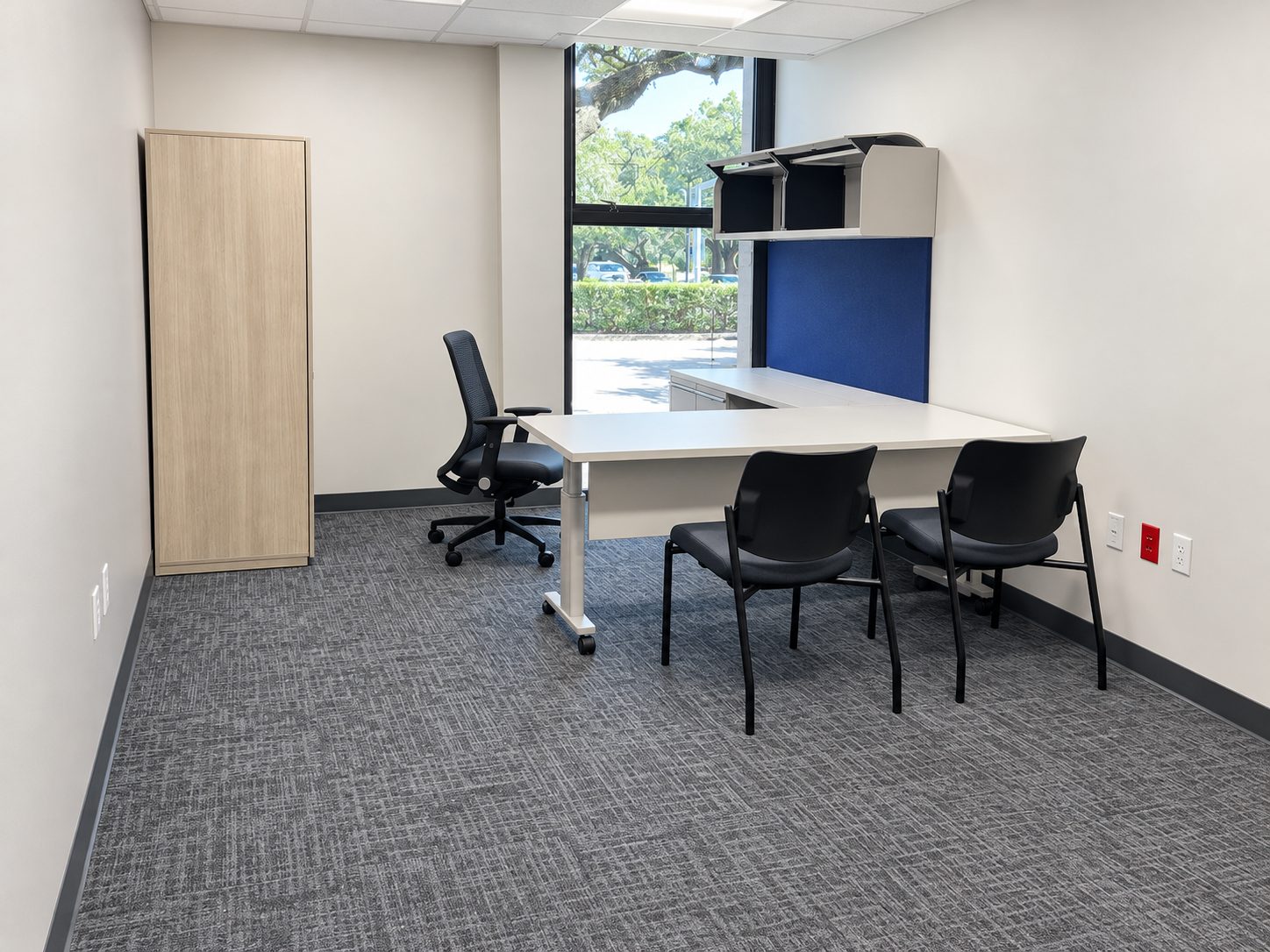 Private office with remanufactured Knoll desk, wardrobe storage and guest chairs beside a window