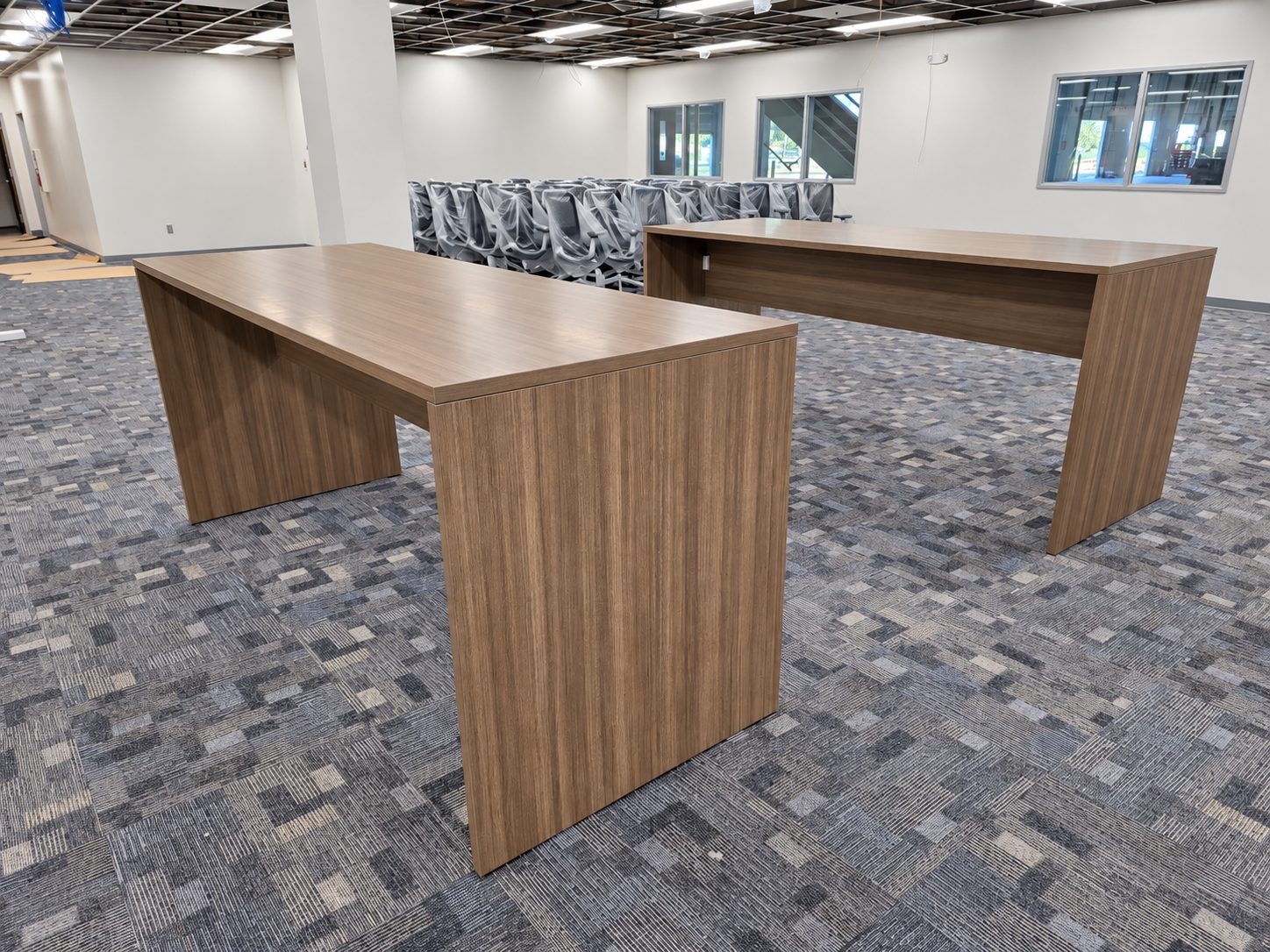 Parsons tables in an open area during construction with ceiling grid still open