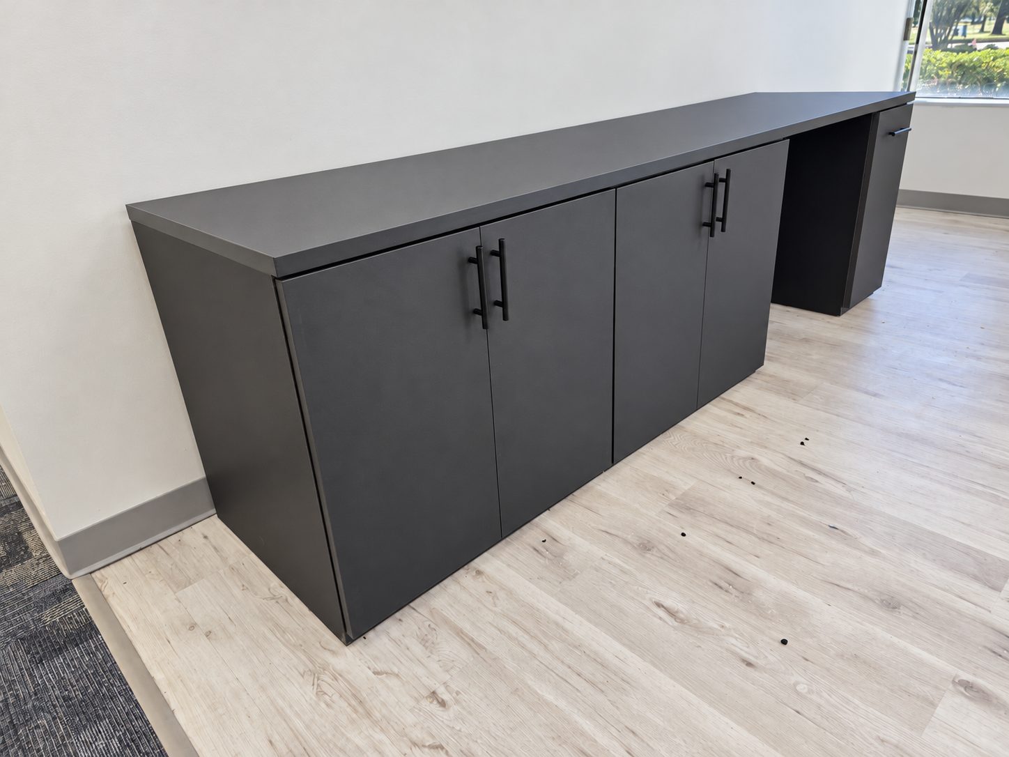 Custom black credenza with storage cabinets in the reception area
