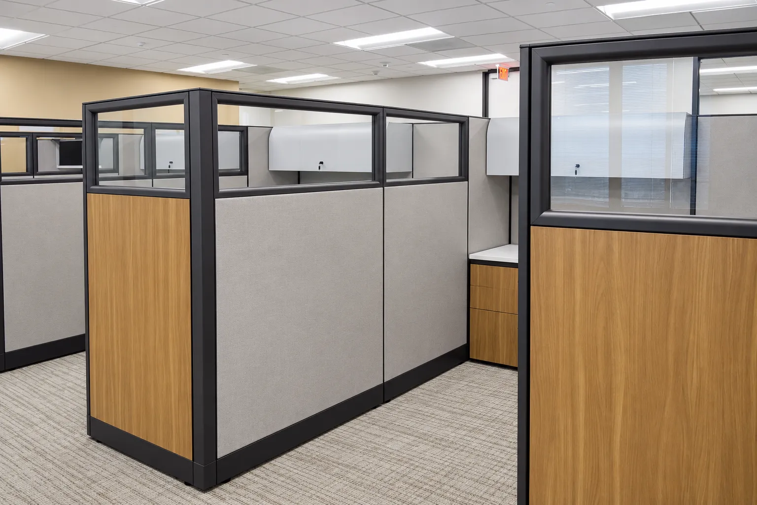 Houston law firm workstations with gray panels, black frames, glass upper panels, and wood finish accents.